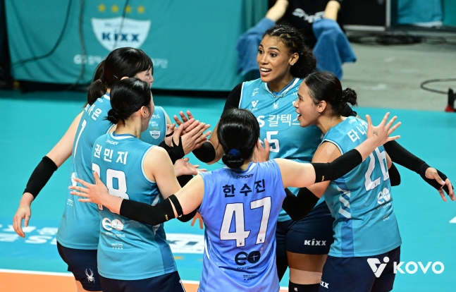 하늘색 유니폼을 입은 GS칼텍스 선수 다섯 명이 코트 위에 둥글게 모여 손을 맞대며 웃고 있다. 18번 권민지, 47번 한수진, 5번 실바, 22번 타나차의 등이 보인다